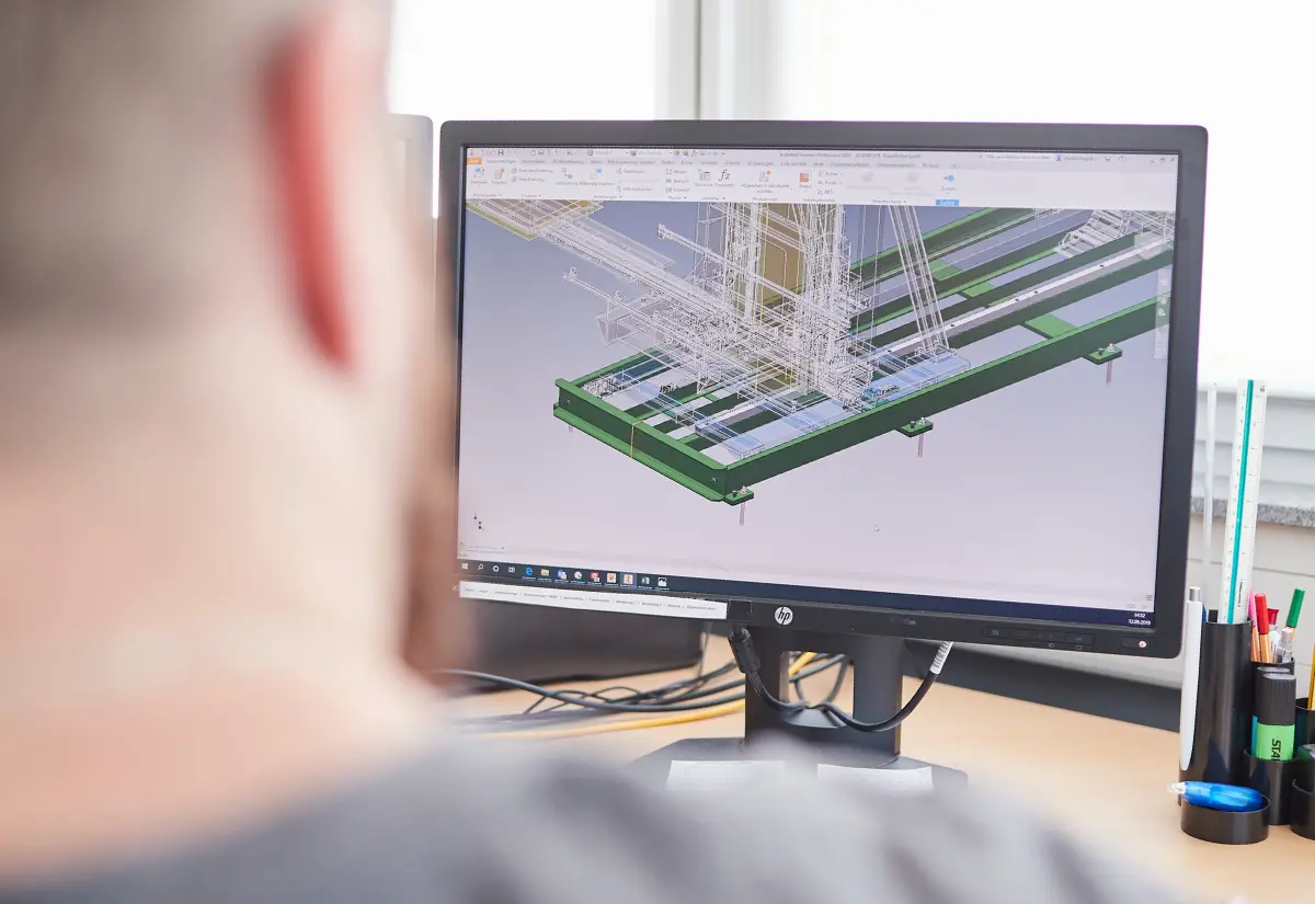 Digitale Konstruktion individueller Fördersysteme im CAD bei ALFATEC 3D-CAD-Modell eines Fördersystems auf Monitor zur Planung und Konstruktion in der Fördertechnik