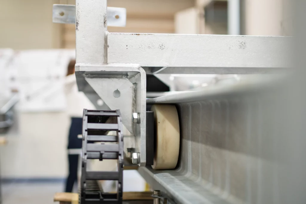 Führungsrollen für stabile und reibungslose Linearbewegungen in der Fördertechnik Führungsrolle in einer Schienenführung für präzise Linearbewegung in einem Fördersystem