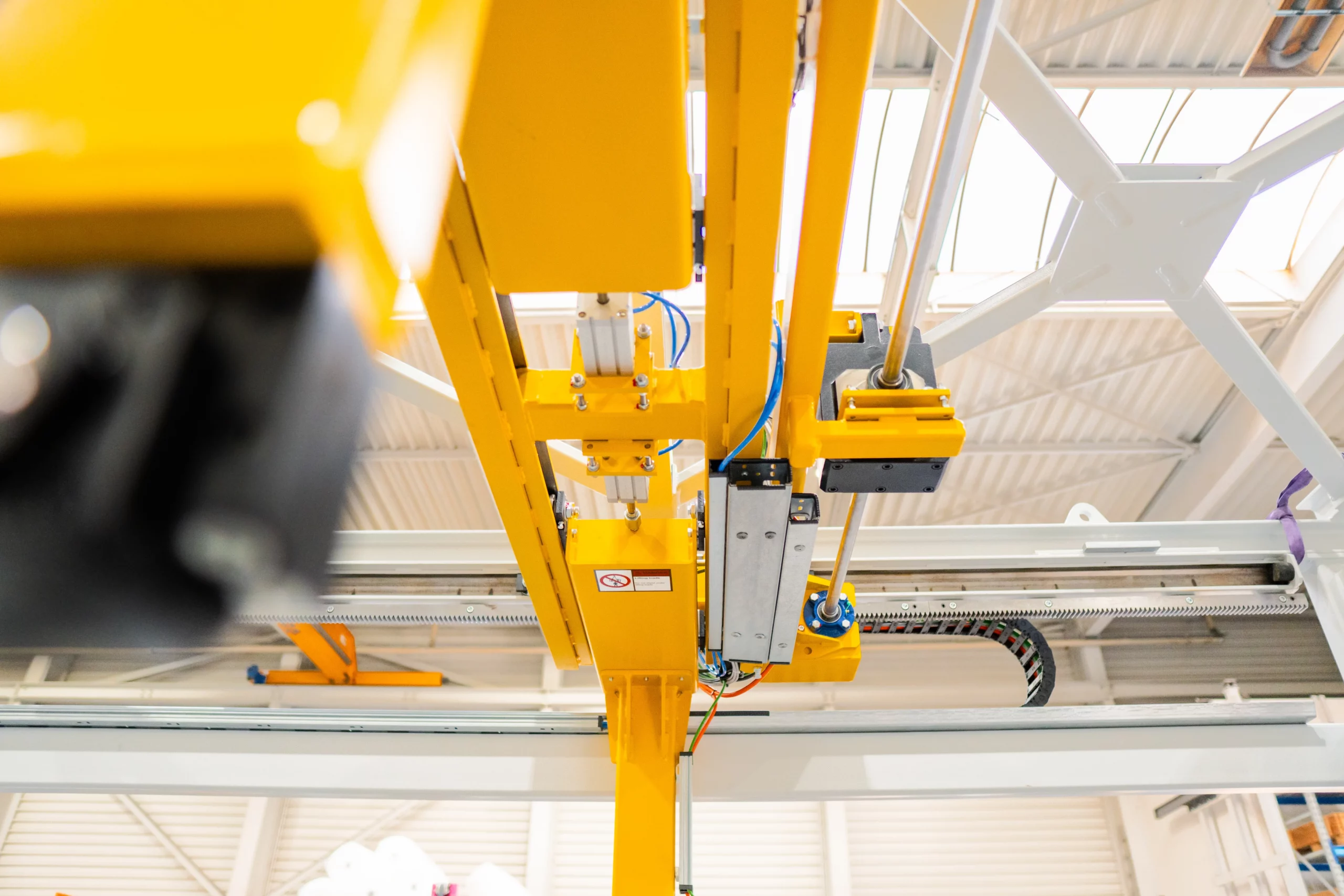 Lineartechnik und präzise Führungssysteme für automatisierte Fördersysteme von ALFATEC Linearführung und Antriebseinheit eines Fördersystems mit Energiekette in industrieller Anwendung