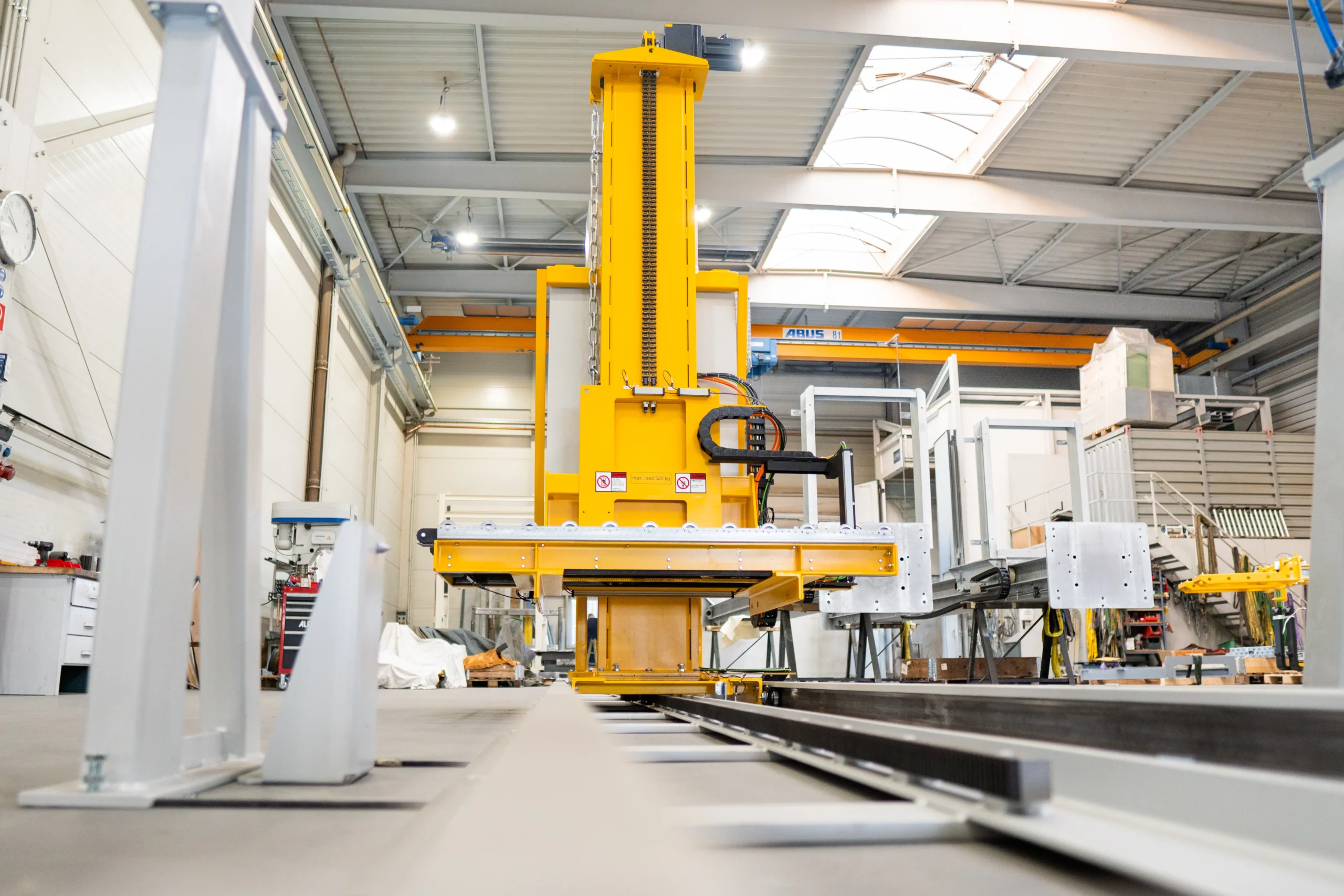 Individuelles Handlingsystem mit Hubmechanik für den automatisierten Materialtransport von ALFATEC Automatisiertes Fördersystem mit vertikalem Hub und Greifeinheit für den Materialtransport in der Industrie